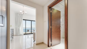 Habitación de hotel moderna con un amplio ventanal corredera que da a un balcón con vistas al mar.