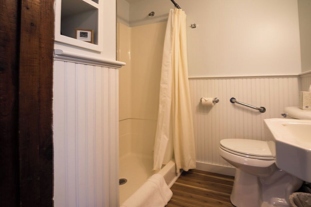A bathroom with a shower, toilet, and sink.