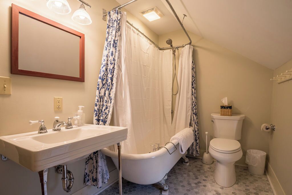 A bathroom with a bathtub, toilet, and sink.