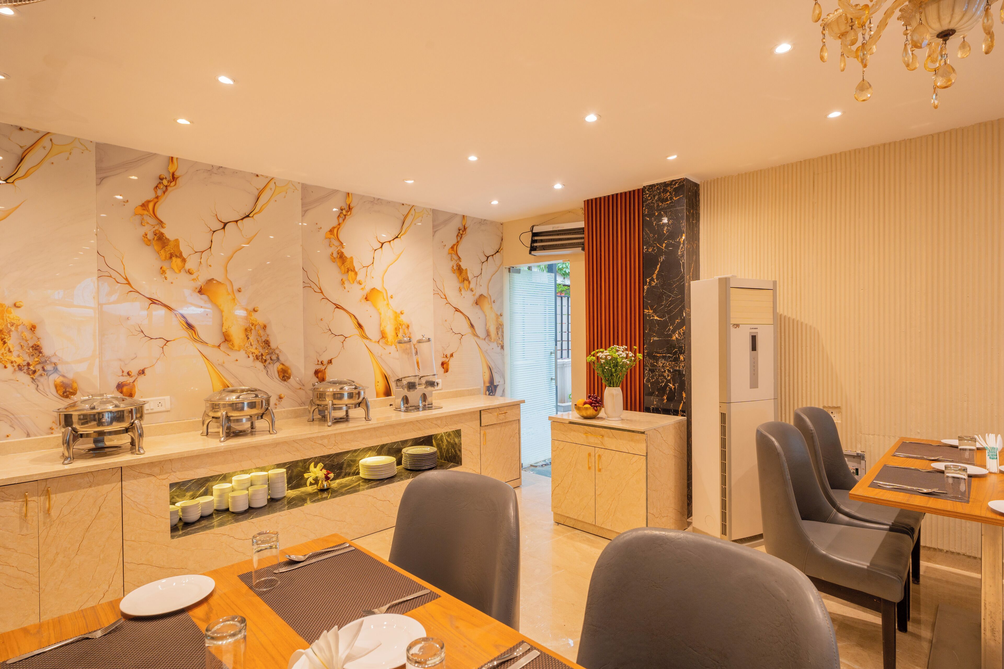 A modern dining area with a marble wall, a kitchen counter, and a dining table with chairs.