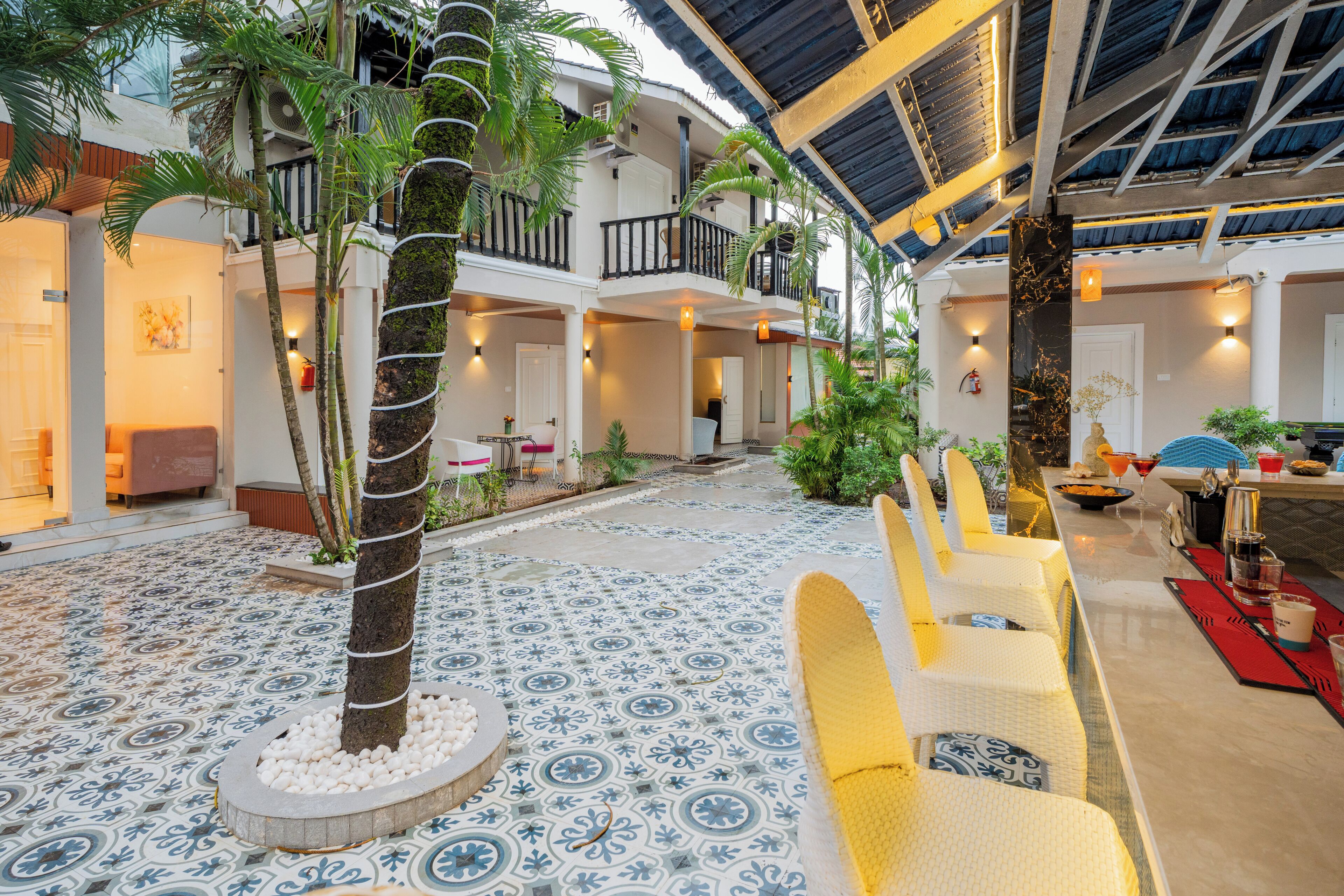 A spacious indoor area with a patterned floor, seating arrangements, and a balcony with railings.