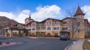 A large, multi-story building with a distinctive red and beige facade, featuring a prominent tower with a conical roof. - Villa 2055 2 Queen Beds - 1 Bedroom 1 Bath No Kitchen 1 Villa (Midway)