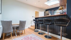 Une cuisine moderne avec un coin bar, un plancher en bois et un tapis à motifs.