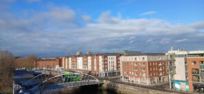 Une vue urbaine avec une rivière, un pont et des immeubles dotés de balcons.