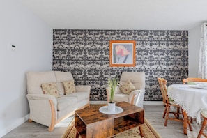 A living room with a sofa, chairs, a coffee table, and a dining table. - Riverside 2BD Flat, Short Walk to the ExCel Centre (Greater London)
