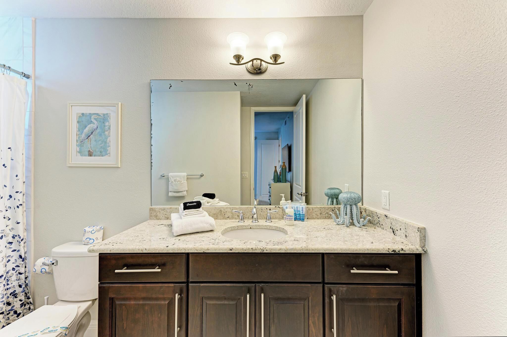 A bathroom with a sink, mirror, and dark wooden cabinets.