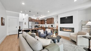 A modern living room with a sectional sofa, a coffee table, and a fireplace.