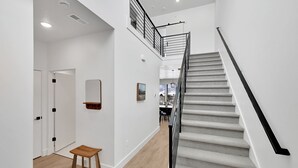A modern interior with a staircase, wooden flooring, and a minimalist design.