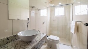 A bathroom with a large vessel sink, a toilet, and a glass-enclosed shower. - ARCA'S EXPRESS HOTEL (Toledo)