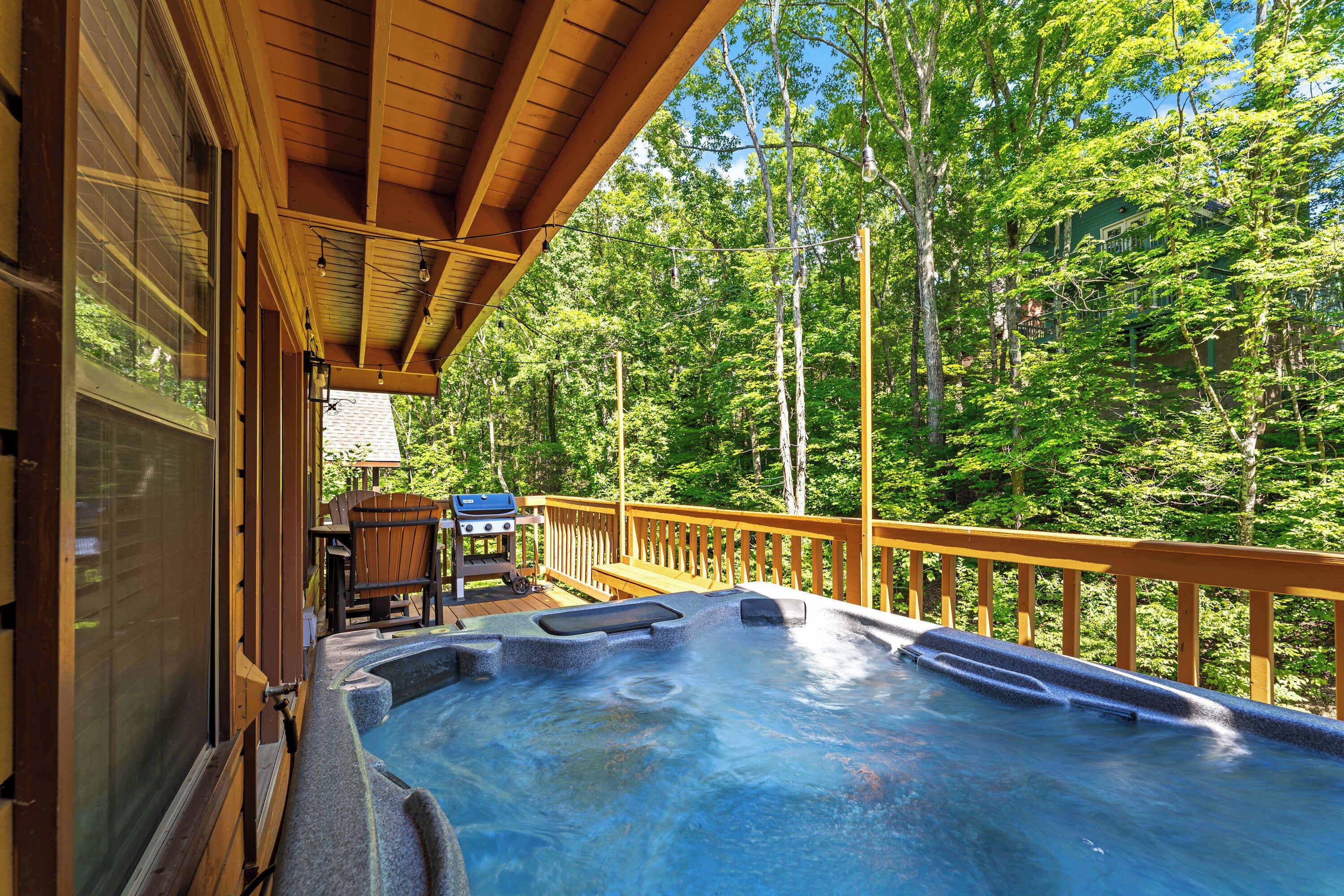 A hot tub on a wooden deck with a view of a forest.