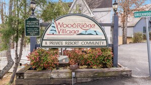 Wegwijzer naar Woodridge Village, een privé-resort, met een verbod op parkeren aan de straat.