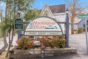 A sign for Woodridge Village, a private resort community, with a prohibition on on-street parking. - Cabin Stay for 12 Close to Pkwy w/Deck & Hot Tub! (Pigeon Forge)