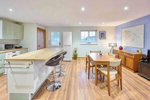 Enjoy meals and relaxation in this well-equipped kitchen and dining area with a central island and comfortable seating.