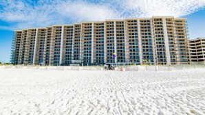 A multi-story hotel with numerous balconies, situated on a sandy beach. - Beachfront 3BR!!  Next door to the Flora-Bama!! (Orange Beach)