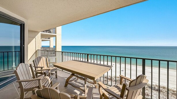 A balcony with a table and chairs, overlooking a beach and the ocean. - Beachfront 3BR!!  Next door to the Flora-Bama!! (Orange Beach)
