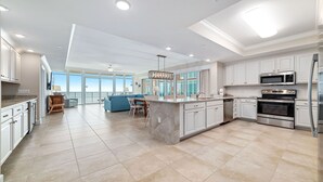 A spacious kitchen with white cabinets, stainless steel appliances, and a large island. - Newest complex on the Alabama Coast!  Lazy River and Slide!! (Orange Beach)