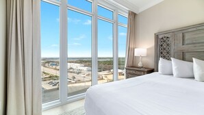 A hotel room with a large window, a bed, a nightstand, and a lamp. - Newest complex on the Alabama Coast!  Lazy River and Slide!! (Orange Beach)