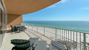 A balcony with a table and chairs, overlooking a beach with a railing. - Newest complex on the Alabama Coast!  Lazy River and Slide!! (Orange Beach)