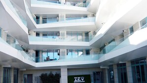 A multi-level atrium with glass railings and a sign for ZEV Mediterraneo. - Cnc Zev Apartment (Navodari)