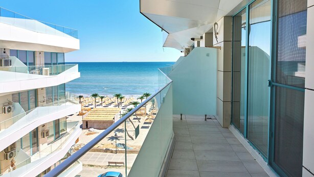 A modern building with a balcony overlooking a beach. - Cnc Zev Apartment (Navodari)