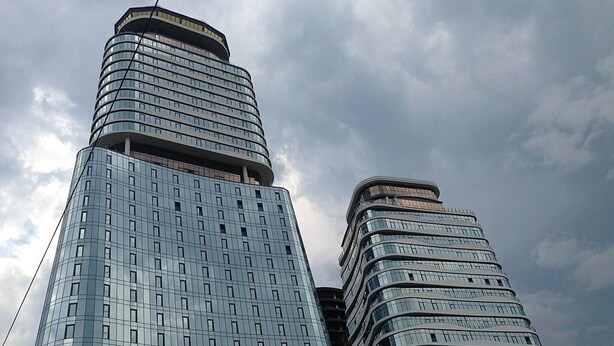 A modern high-rise building with a curved facade and multiple floors. - King David standard two bedroom 24 (Tbilisi)