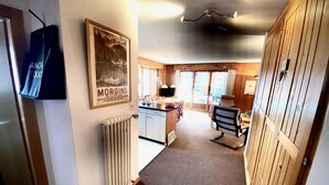 A cozy interior with a kitchen area, wooden paneling, a dining table, and a framed picture on the wall. - Pre Vert D62, Morgins (Morgins)
