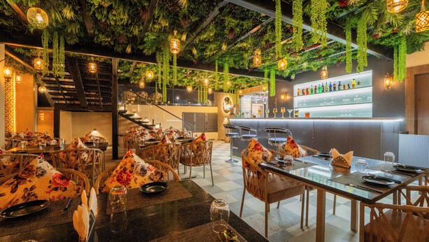 A restaurant with tables set for dining, a bar area, and a staircase leading to an upper level. - Royal Prime - A City Center Botique Hotal in Jaipur (Jaipur)