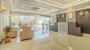 A modern reception area with a glass partition, a reception desk, and a seating area with chairs and potted plants. - Royal Prime - A City Center Botique Hotal in Jaipur (Jaipur)