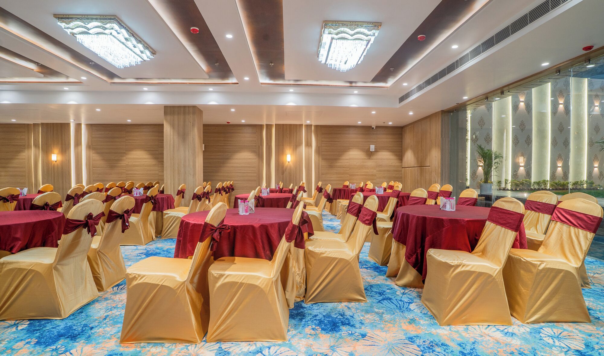 A conference room with round tables and chairs, large windows, and a patterned carpet.