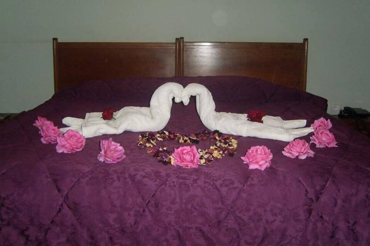 Ein Bett mit violetter Bettdecke und einem Holzkopfstück.