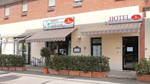 A hotel with a sign for 'Hotel Restaurant Bar Garibaldi' and 'Hotel MOKASIRS'. - Hotel Garibaldi (San Quirico d'Orcia)
