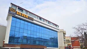 A modern hotel with a large glass facade, a prominent 'Silver Suite' sign, and a contact number. - 216 Silver Suite (Tuzla)