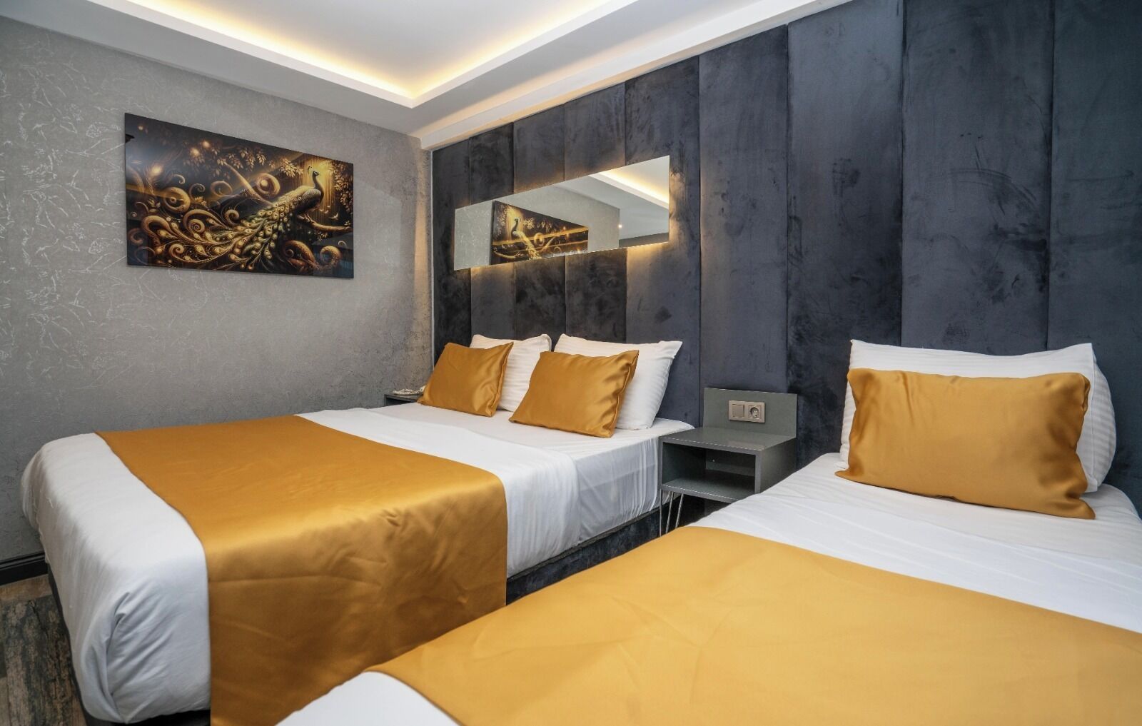A hotel room with two beds, a large mirror, and a decorative wall piece.