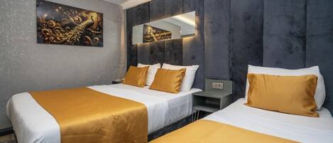 A hotel room with two beds, a large mirror, and a decorative wall piece.