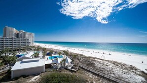 Ein Strandresort mit Pool, Strandsonnenschirmen und Blick aufs Meer.