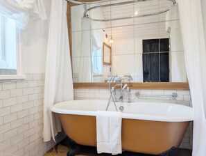 Bathroom features a bathtub and a large mirror.