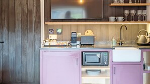 Una cucina compatta con forno a microonde, tostapane e lavello.
