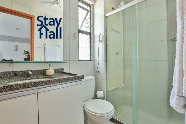 A bathroom with a shower, toilet, and sink.