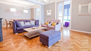 A spacious living room with a herringbone wood floor, a sofa set, a coffee table, and a chandelier. - ELEGANT APARTMENT IN THE CENTER OF BARCELONA (Barcelona)