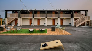 Ein Motel mit mehreren Zimmern, Außenbereich mit Sitzgelegenheiten und einem kleinen Spielplatz.