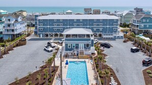 Un hôtel situé en bord de mer, doté d’une piscine, de plusieurs balcons et offrant une vue sur l’océan.