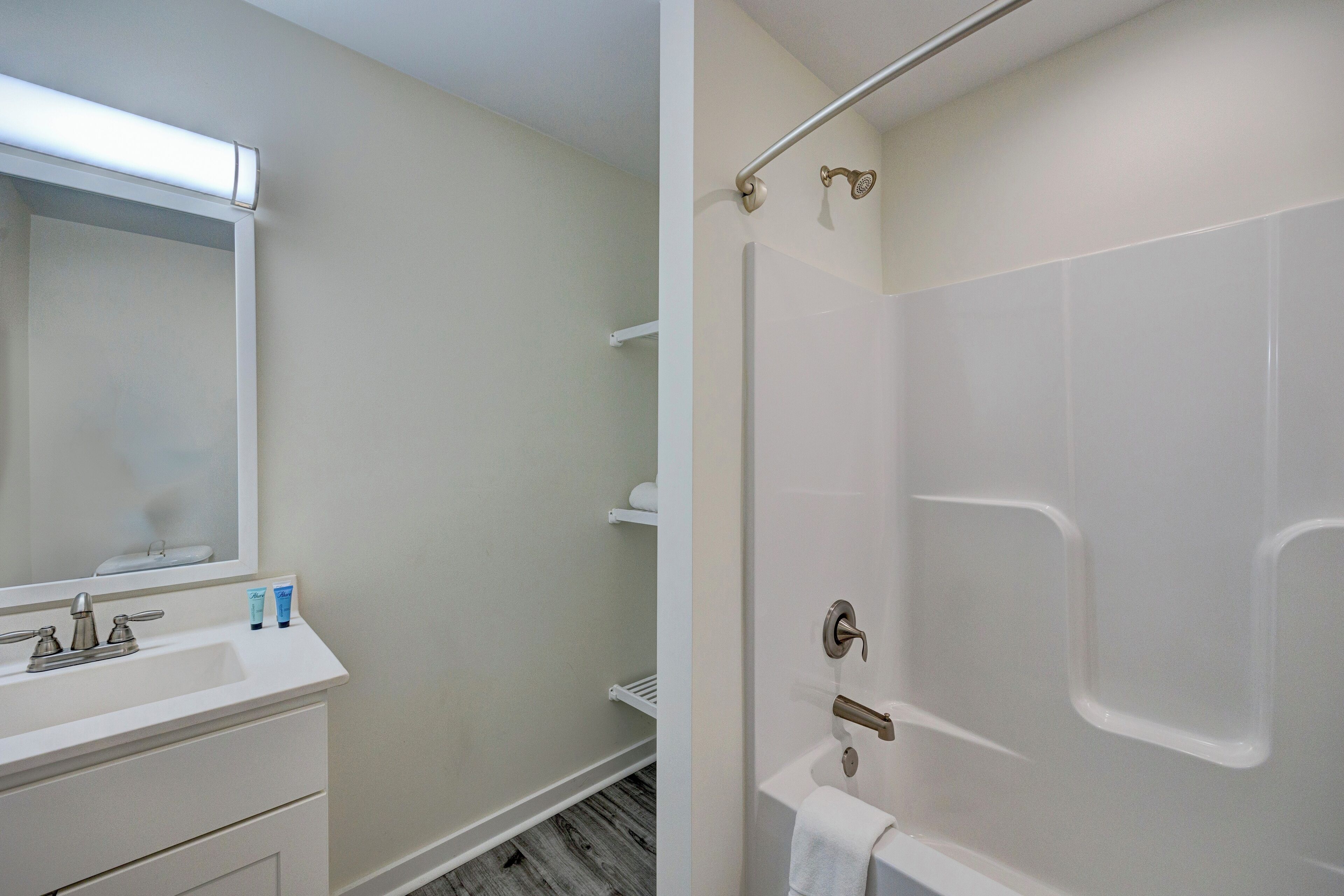 Une salle de bain avec un lavabo blanc, un miroir et une douche.