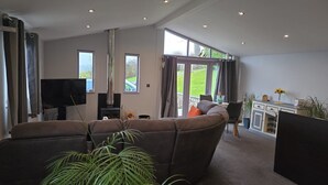 A spacious living room with a large sofa, a fireplace, and a television. - Haven Lodge Kirkby In Furness -  a lodge that sleeps 2 guests  in 1 bedroom (Kirkby in Furness)