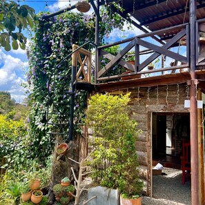 A rustic wooden structure with a wooden staircase leading to a covered area. - Ecohotel Zona 7 (Rionegro)