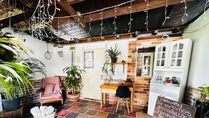 A cozy cafe with a brick wall, wooden furniture, and hanging lights.
