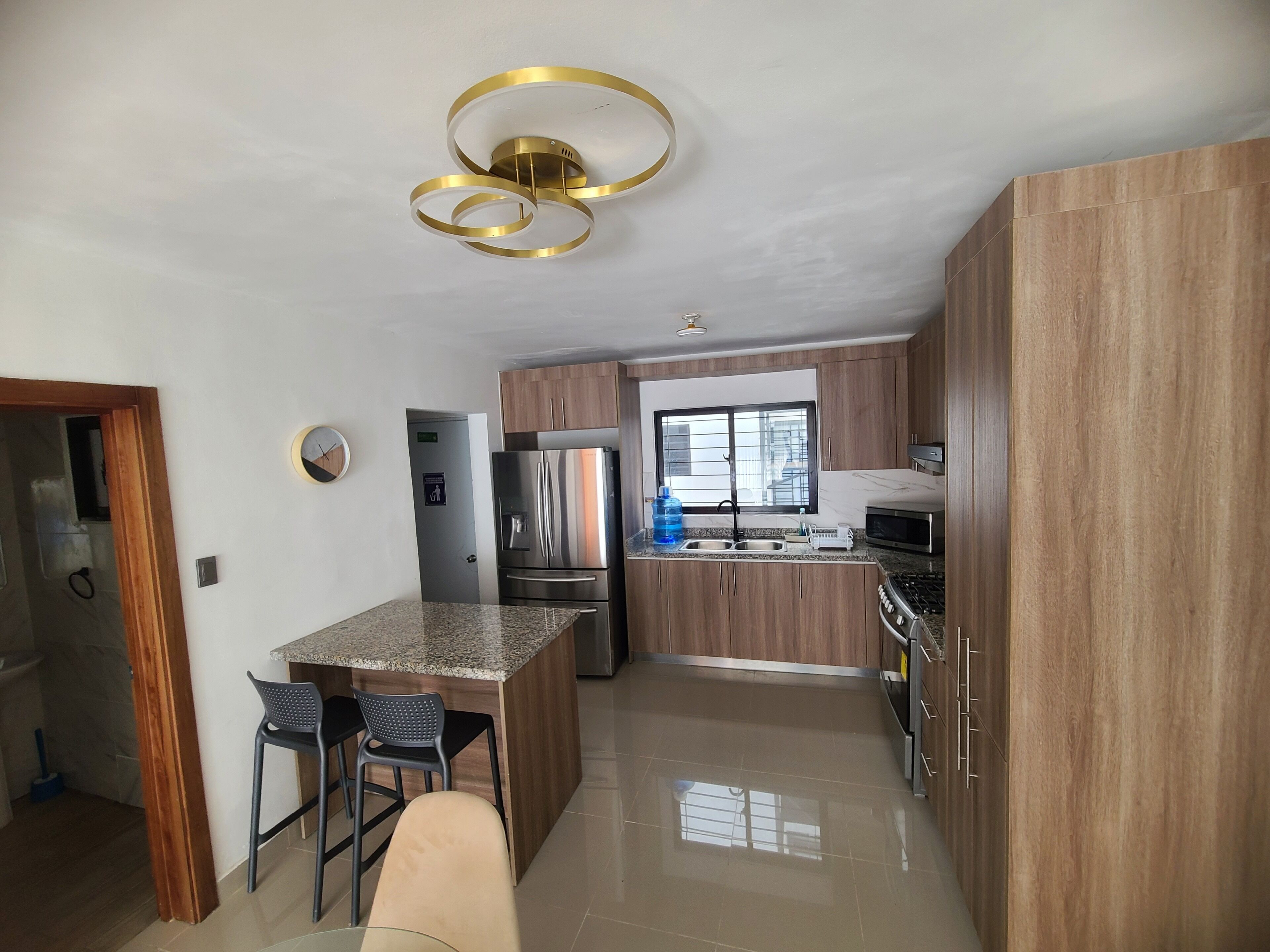 A modern kitchen with granite countertops, stainless steel appliances, and wooden cabinetry.