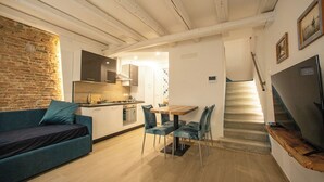 A compact living space with a kitchen, dining area, and a staircase.