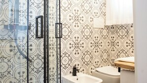 Ein Badezimmer mit Duschkabine, Bidet und Toilette.