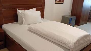Un letto rifatto con lenzuola bianche in una camera d'albergo.