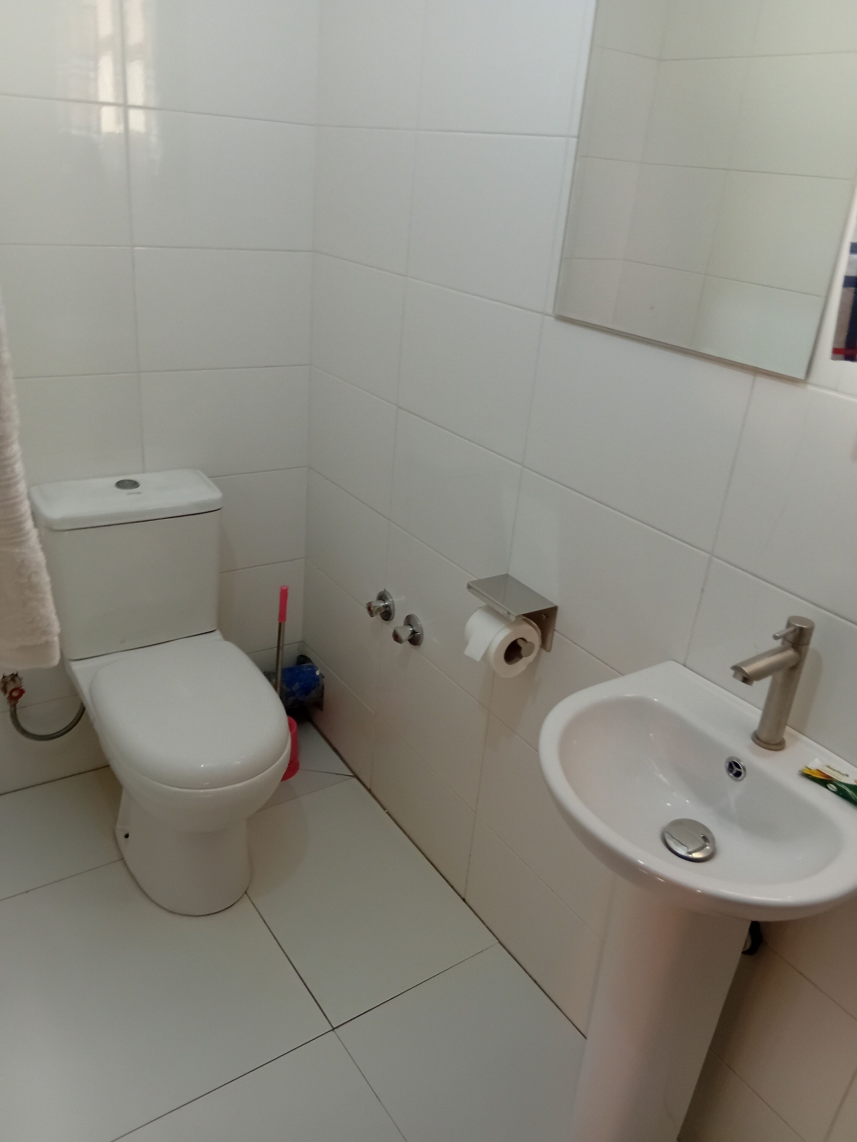 Ein Badezimmer mit Toilette, Waschbecken und Spiegel.